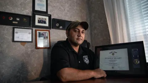 Dustin Duong for the BBC Zia Ghafoori shows his Purple Heart, awarded for injuries in the Shok Valley battle