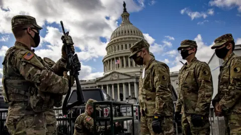 Getty Images National Guard troops take up weapons as they guard the US Capitol after rioters attacked the building January 2021
