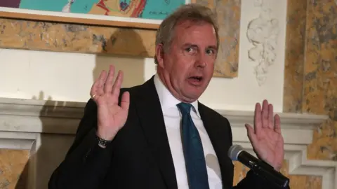 Getty Images Outgoing British Ambassador to the US Sir Kim Darroch speaks during an annual dinner of the National Economists Club at the British Embassy in October 2017 in Washington, DC