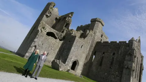 Getty/Debbie Hickey TIPPERARY, IRELAND - MARCH 25: Camilla, Duchess of Cornwall and Prince Charles, Prince of Wales pose in front of the cathedral during a visit at the Rock of Cashel on March 25, 2022 in Tipperary, Ireland. This is the fifth time that The Prince of Wales and The Duchess of Cornwall have officially visited Ireland together. The tour takes place as Queen Elizabeth II celebrates her Platinum Jubilee year. (Photo by Debbie Hickey/Getty Images)