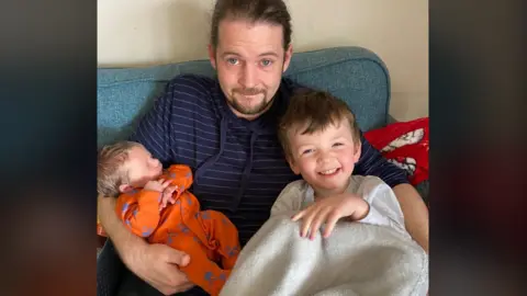 Phil Cole A father holds his two sons