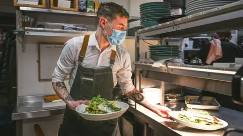 Getty Images Waiter wearing face mask