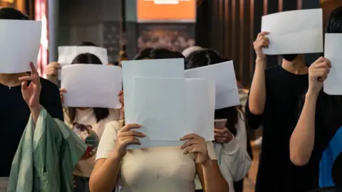 Getty Images People protesting in China with blank pieces of paper.