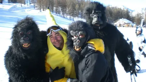 Andy Watts James Kirby dressed as a banana with three people dressed as gorillas on top of a snow-clad mountain