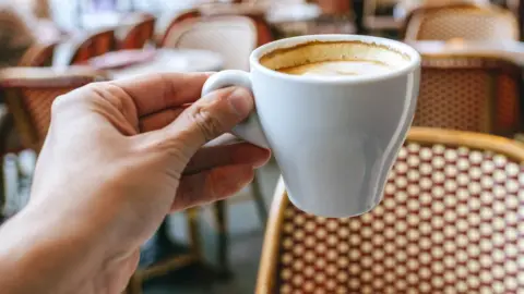 A man holding a cup of coffee