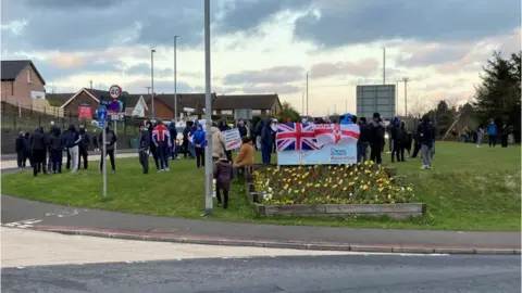 Protesters gathered at a roundabout in Larne, County Antrim on Tuesday evening