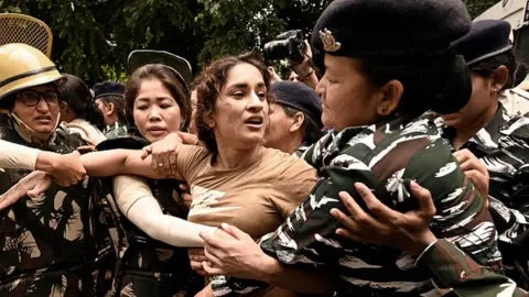 Getty Images Security personnel detain wrestler Vinesh Phogat during wrestlers' protest march towards new Parliament building, on May 28
