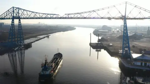 PD Ports Dredger sails beneath bridge