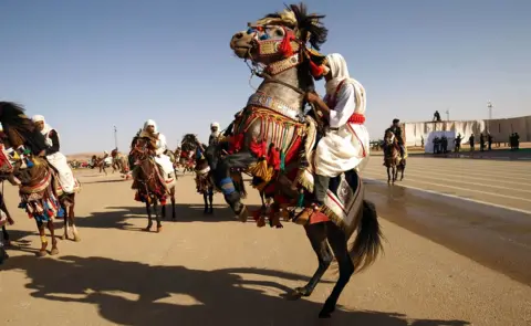 AFP Libyan dressed in traditional costumes attend a military parade in the eastern city of Benghazi on May 7, 2018, during which Libyan strongman Khalifa Haftar announced a military offensive to take from "terrorists" the city of Derna, the only part of eastern Libya outside his forces" control.