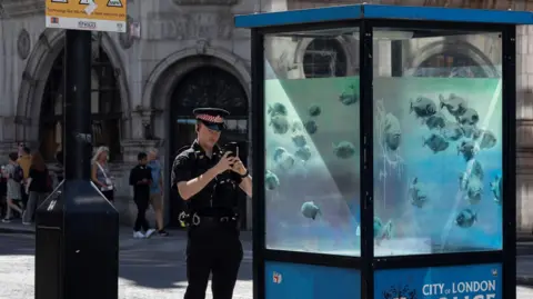 Banksy Police officer taking a photo of the sentry box