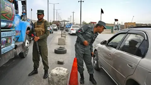 AFP Afghan police stand guard at a checkpoint along the road in Kabul on August 14, 2021