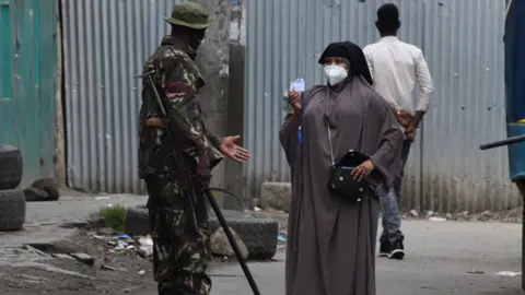 Getty Images An officer suspect the identification of a person in a coronavirus hotspot in Nairobi