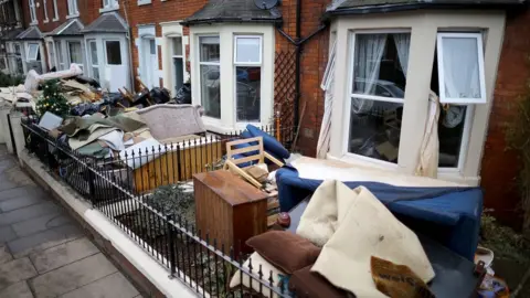 Getty Images Water-damaged possessions sit outside a flooded home in Carlisle after flooding created by Storm Desmond