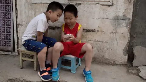 Getty Images Children on a mobile phone