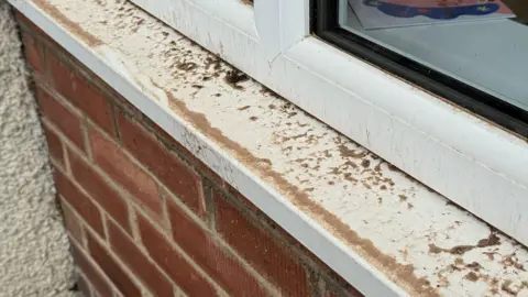 Dust covering a window sill outside a house on Radbourne Lane in Derby