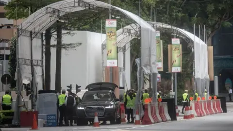 Getty Images Police inspect vehicles at a checkpoint near Singapore's St Regis Hotel ahead of Mr Kim's expected arrival there