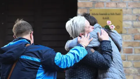 EPA Mourners hug in front of the synagogue in Halle, 10 October