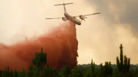 Reuters A firefighting aircraft drops flame retardant in the Gironde region, south-western France. Photo: 10 August 2022