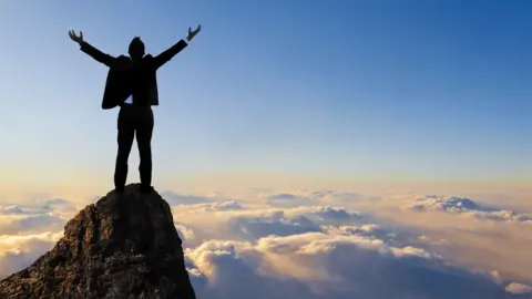 Getty Images Person at the top of a mountain