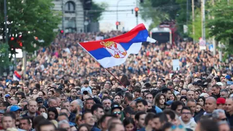 Serbian flag waves amongst crowd of protesters