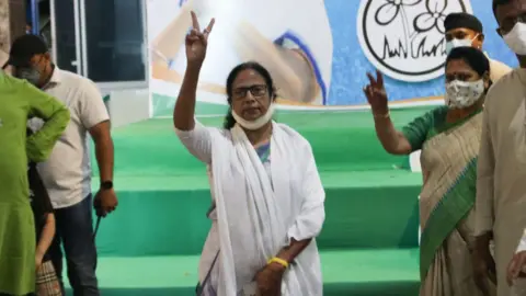 Getty Images Mamata Banerjee shows the victory sign at a news conference in Kolkata, India, on 2 May 2021