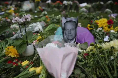 PA Media People leave flowers outside Windsor Castle, Berkshire, following the death of the Duke of Edinburgh