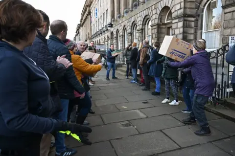 Jeff J Mitchell/Getty Images Aid parcels being loaded on to a van by volunteers