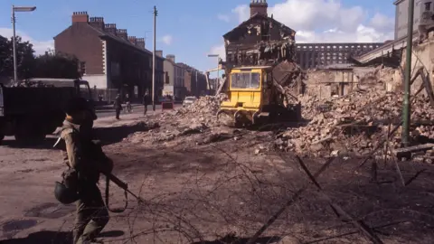 PA Media A soldier at a barbed wire barrier on the Falls Road in Belfast in 1969