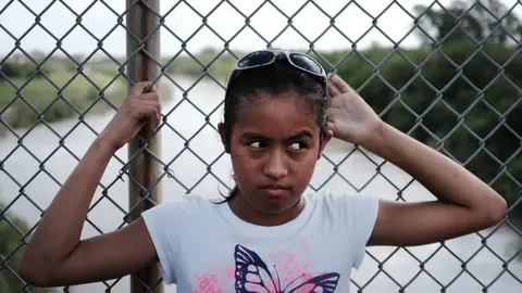 Getty Images A girl waits on a bridge at the US-Mexico border