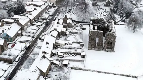 An aerial scene showing snow covering the village of Bowes, including Bowes Castle, in County Durham.