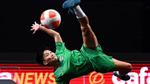 Thai teqball player Jutatip Kuntatong completes acrobatic overhead kick
