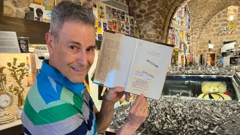 Uri Geller holds a copy of The Geller Papers