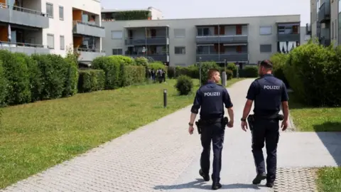 Reuters Two police officers walking towards a low-rise building where the 21-year-old suspect lived.