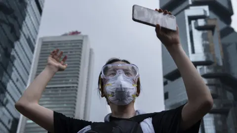 Getty Images A protester holds a mobile phone