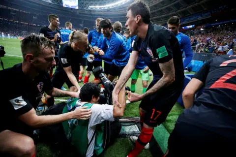 Carl Recine/Reuters Croatia's Mario Mandzukic helps an AFP photographer Yuri Cortez to his feet after celebrating scoring their second goal