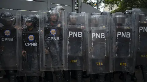 Getty Images A large group of Venezuelan National Police officers block a street during a demonstration against the government of Nicolas Maduro organized by supporters of Juan Guaido on March 10, 2020 in Caracas, Venezuela