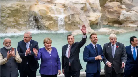 Getty Images World leaders wave to the cameras in front of the Trevi fountain