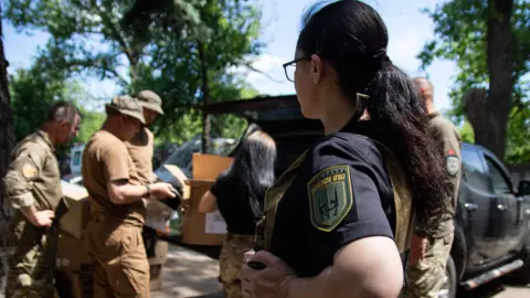 Jess Daly "Baghira" (pictured in blue uniform) helps run the Hospitallers Volunteer Medical Battalion