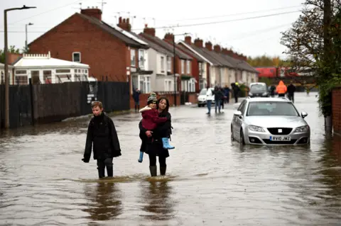 AFP Residents walk through flood water