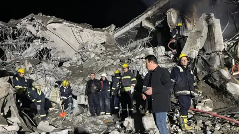 Anadolu First responders search through the rubble of a damaged building in Irbil, northern Iraq, following overnight Iranian ballistic missile strikes (16 January 2024)