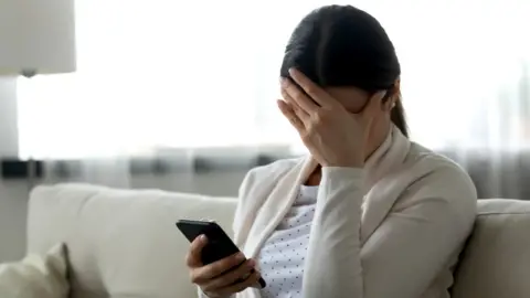Getty Images Woman looks at phone