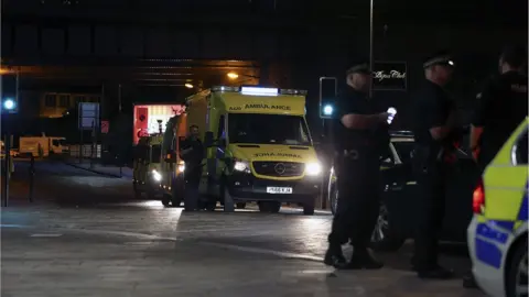 EPA Police officers at the attack scene as ambulances leave