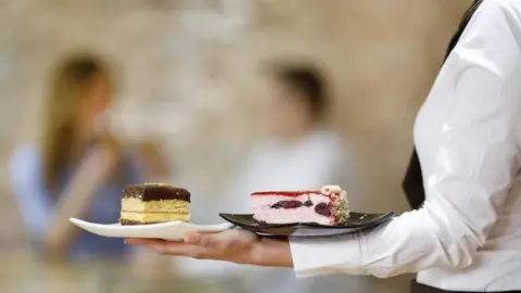 Getty Images Waitress holding desserts