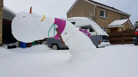Suse and Mike Limbo snowman. Suse and Mike said: "Relentless easterly 'Beast from the East' wind overnight has turned our snowman into a limbo dancer! That it hasn't fallen is obviously testament to our building skills!"