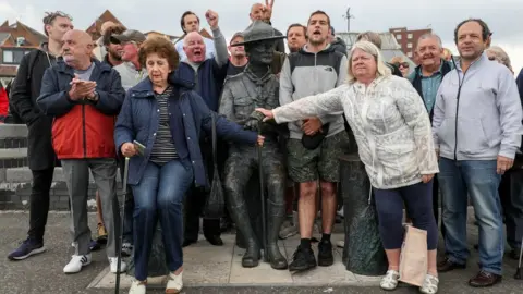 PA Media Local residents at statue