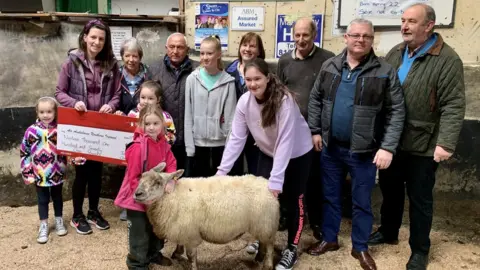 Air Ambulence NI Georgia Hamilton (centre) handed over the cheque with her mum and three sisters