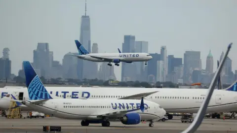  United Airlines plane lands at Newark Liberty International Airport in front of the New York skyline on September 17,