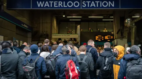 PA Media Commuters queue for the underground to resume at Waterloo station in London, as tube services remain disrupted following a strike