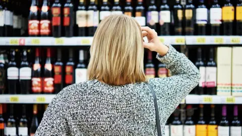 Getty Images Woman shopping in off licence