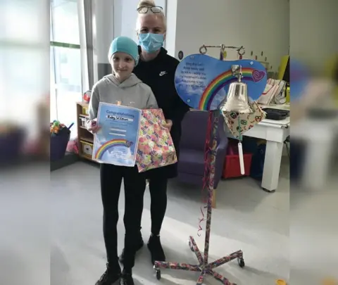 Family photograph Ruby and her mum with the bell and a certificate